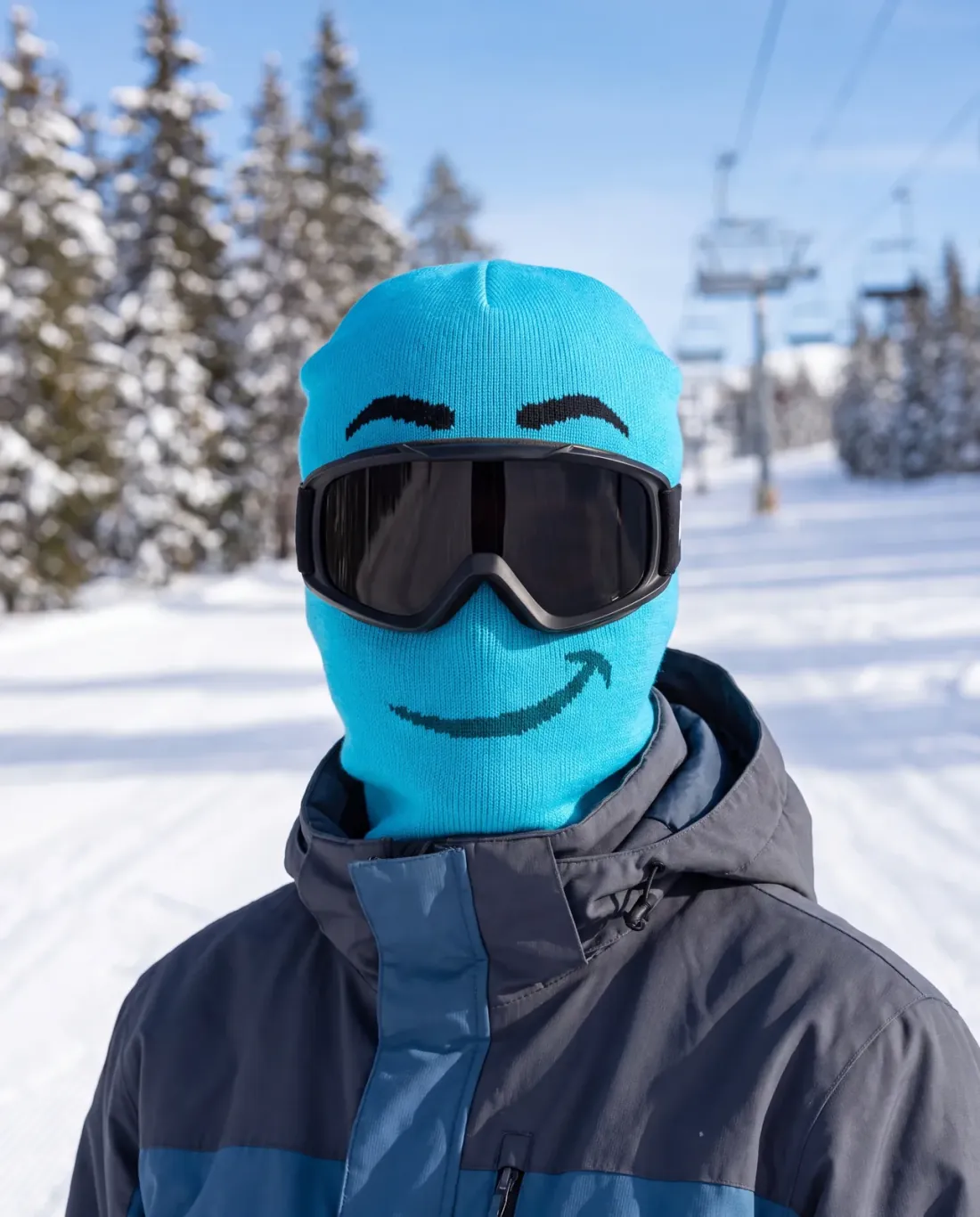 Linnea K. wearing the GRIMM noggos. character ski mask on a chairlift